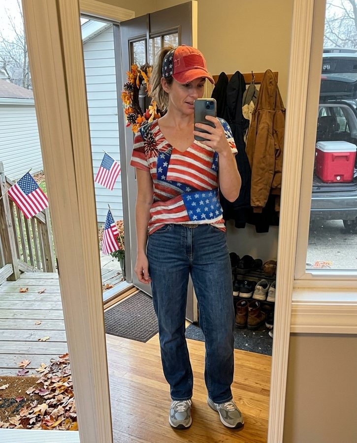 Woman in a flag print ponytail baseball cap taking a mirror selfie