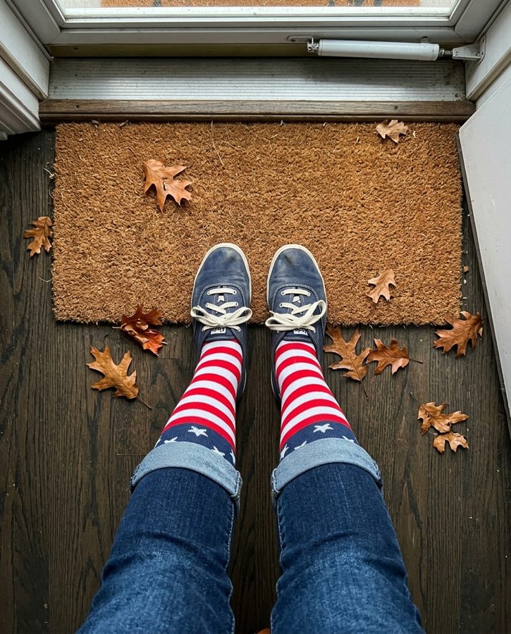 Stars and stripes knee-high socks photographed on the floor by a pair of sneakers